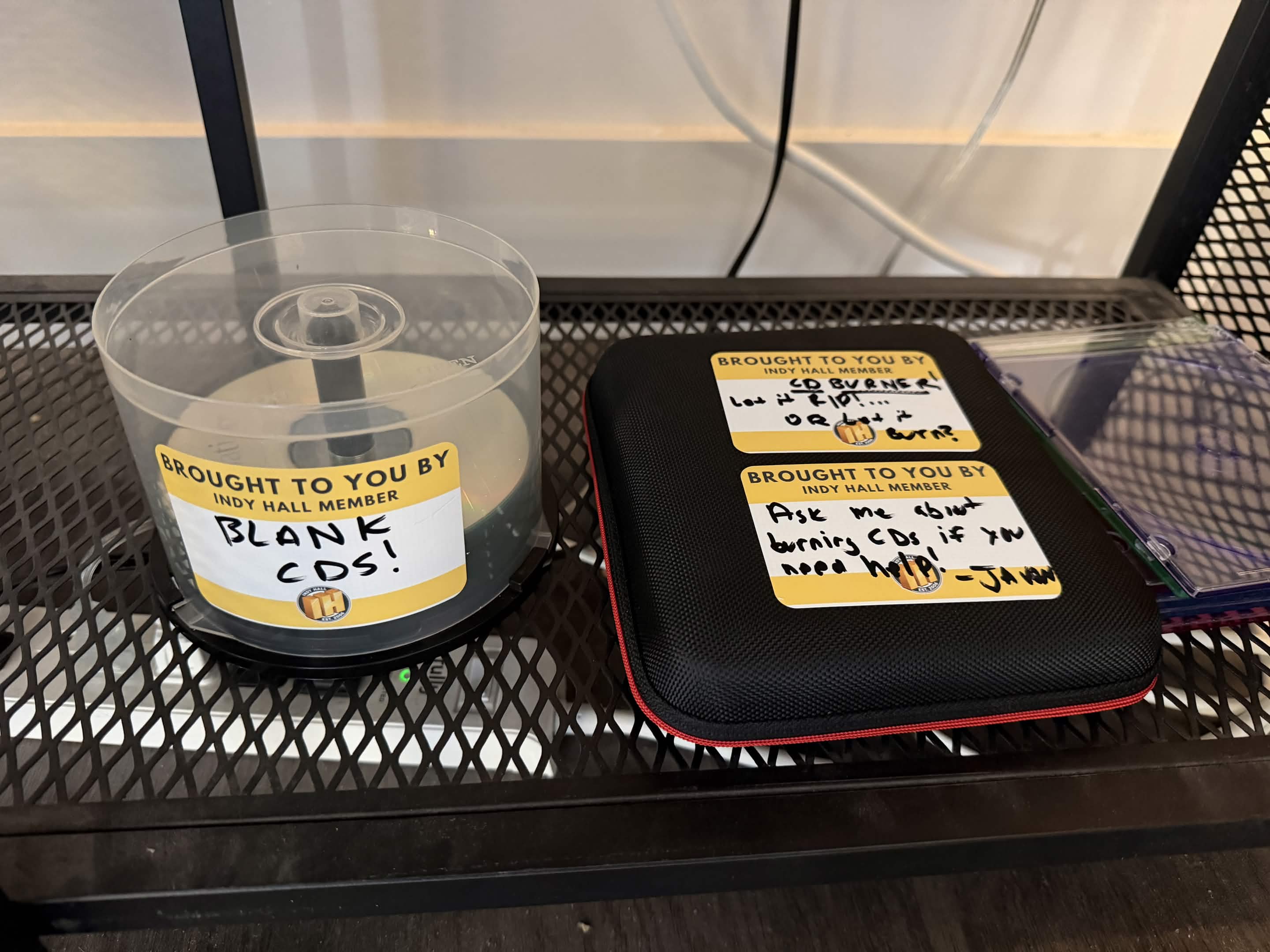 Spindle of blank CDs and a CD burner on the Indy Hall shelf